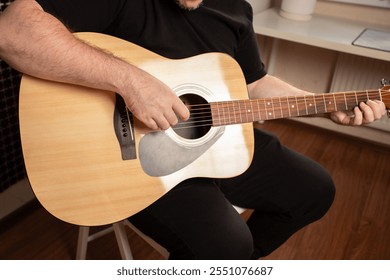 Man Playing Acoustic Guitar, hand strumming strings with skill, learning instrument through practice and study. - Powered by Shutterstock