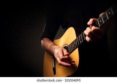 Man Playing Acoustic Guitar In Low Light Environment. Acoustic Guitarist Concert, Unplugged Performance.