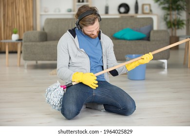 Man Playing Air Guitar With Floor Mop