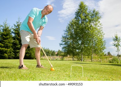 Man Playing Croquet On Cottage