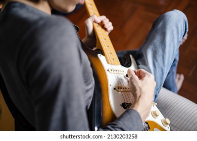 A Man Playing Electric Guitar On A Bed