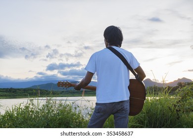 Man Playing Folk Guitar With Nature Sunset Light.selective Focus.