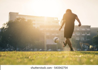 Man playing football at green field on morning. - Powered by Shutterstock