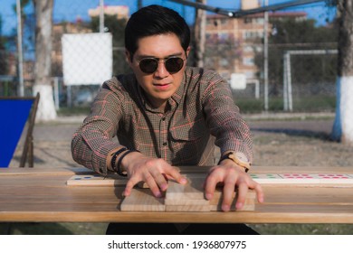 Man Playing Giant Domino On A Wooden Table