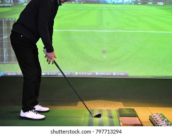 A Man Is Playing Golf At ? Screen Golf Driving Range 