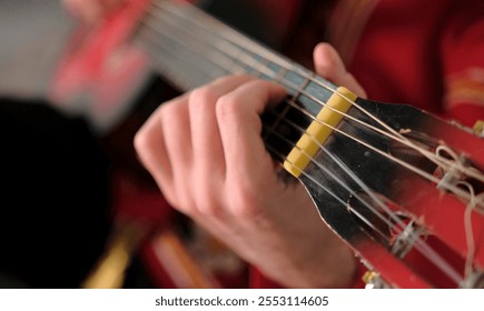 A man is playing a guitar, close-up, focus on the strings and neck of the guitar. The musician strums the guitar. A classical musical instrument. The concept of relaxation and enjoyment - Powered by Shutterstock