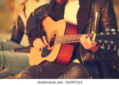 Man Playing Guitar For Girl On Beach