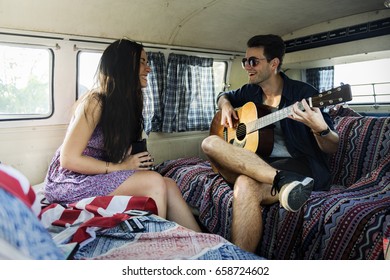 Man Playing Guitar with Lover in a Van Road Trip - Powered by Shutterstock