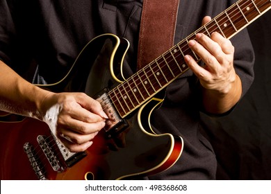 A Man Is Playing Guitar On Stage.