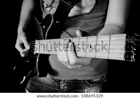 Man playing guitar. Selective focus on his left hand on guitar 