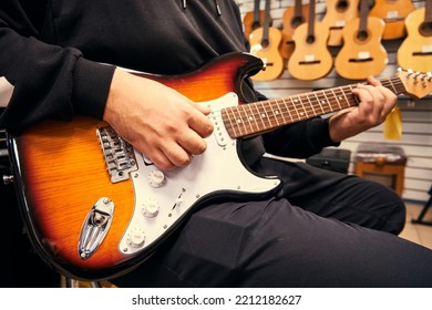 Man Playing The Guitar In The Guitar Shop