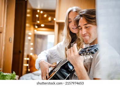 Man Playing Guitar, Singing Song On Small Kitchen,cooking In Van. Young Girl,guy Just Married Couple,lovers Traveling In Camper,house On Wheels,trailer,motor Home. Love Romantic Road Travel Vacation.