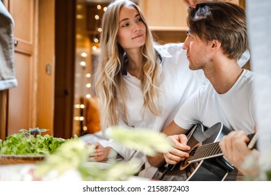 Man Playing Guitar, Singing Song On Small Kitchen,cooking In Van. Young Girl,guy Just Married Couple,lovers Traveling In Camper,house On Wheels,trailer,motor Home. Love Romantic Road Travel Vacation.