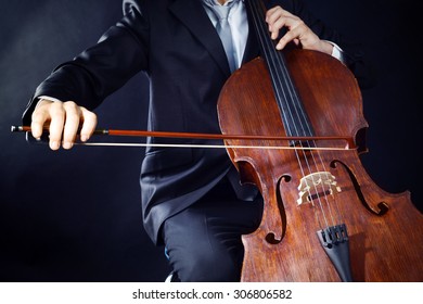 Man Playing On Cello On Dark Background