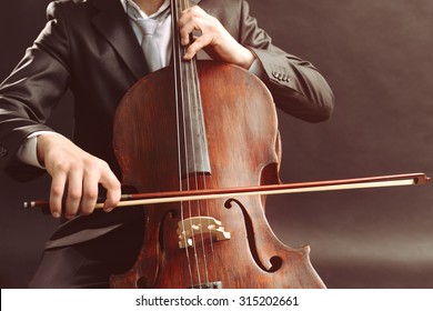 Man Playing On Cello On Dark Background