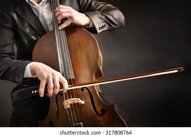 Man Playing On Cello On Dark Background