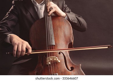 Man Playing On Cello On Dark Background