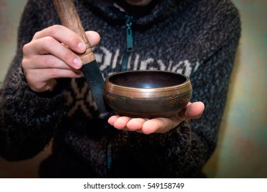 Man playing on a singing bowl - Shutterstock ID 549158749