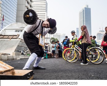 a man playing pantomime by lifting fake barbells on Thamrin street,  Jakarta. 22 July 2018