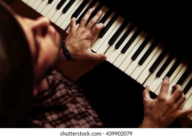 Man Playing Piano On Dramatic Dark Stage