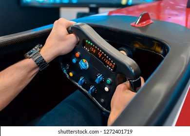Man playing a racing video game - driving f1 simulator  - Shutterstock ID 1272401719