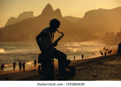 Man Playing Sax On Ipanema Beach, Rio De Janeiro.