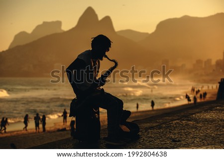 man playing sax on Ipanema beach, Rio de Janeiro.