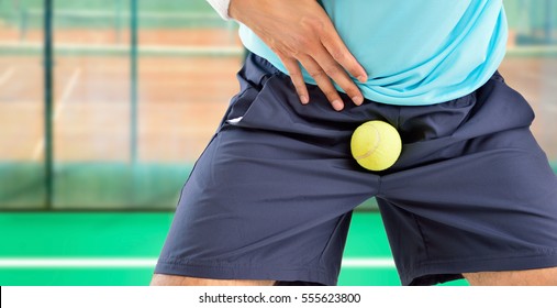 man playing tennis being hit by a tennis ball with force in the crotch when he misses a catch or as an unexpected accident