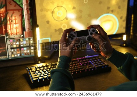 Man playing video games with controller at table indoors, closeup
