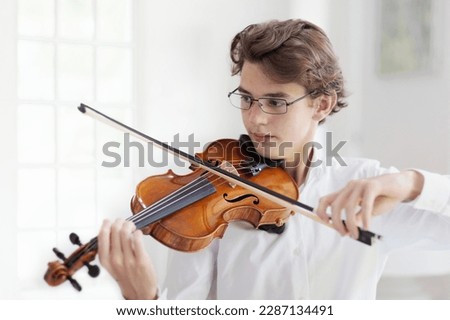 Man playing violin. Classical music instrument. Teenage boy practicing viola. Teenager art school student.