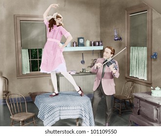 Man Playing Violin For Woman Dancing On Table