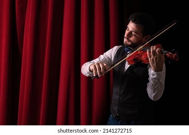 Man playing violin. Young man in theater playing violin. Violinist playing in front of his audience  Copyspace. background. - Powered by Shutterstock