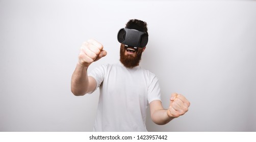 Man Playing And Watching Through VR Device Learning To Drive And Being Excited.