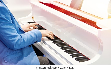 Man Playing White Grand Piano