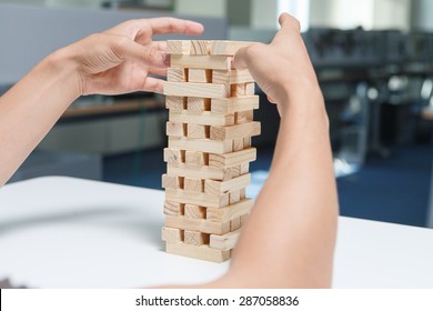 Man Playing With The Wood Game (jenga) In The Office