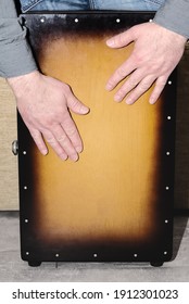 The man plays the cajon drum. Drummer's hands while practicing percussion instrument.