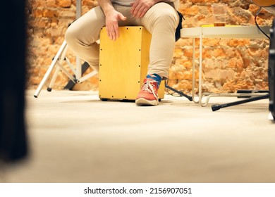 A man plays the cajon, a percussion instrument. Concert, view from the lowest point. Copy space.