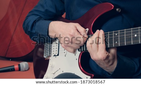 Man plays a guitar in the background you can see a microphone and a second guitar Stockfoto © 