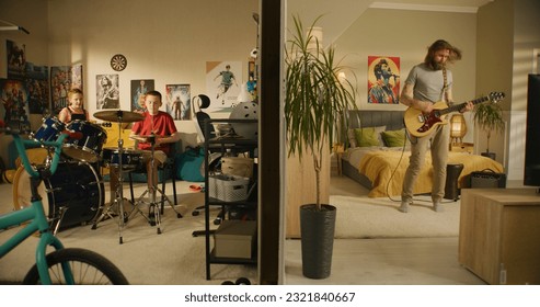 Man plays guitar in bedroom. Young boy plays drum kit and young girl plays ukulele, jumps on bed. View of two rooms or apartments separated by wall. Concept of music, neighbourhood and lifestyle. - Powered by Shutterstock