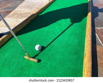 Man Plays In Mini Golf. Ball And Mini Golf Club, Close Up