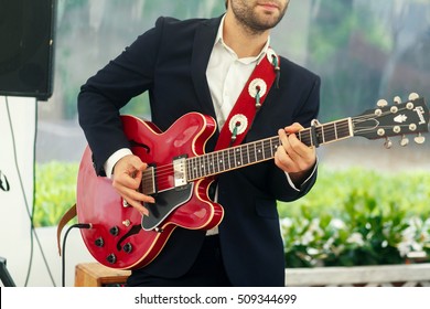 Man Plays Red Guitar Standing On The Porch