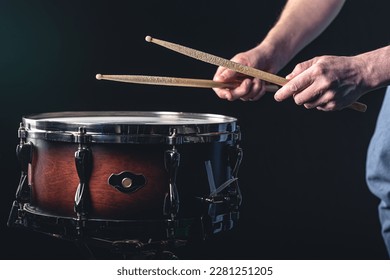 A man plays the snare drum against a dark background. - Powered by Shutterstock