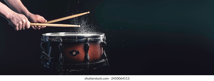 A man plays a snare drum on a dark background, copy space. - Powered by Shutterstock