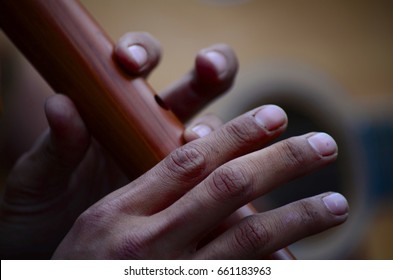 A Man Plays A Wooden Flute Outdoors