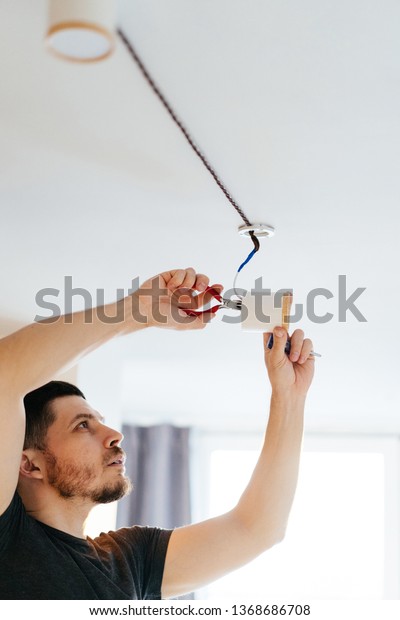 Man Pliers Hands Repairing Lamp On Stock Photo Edit Now 1368686708