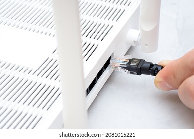 Man Plugging Internet Cable Into The Router