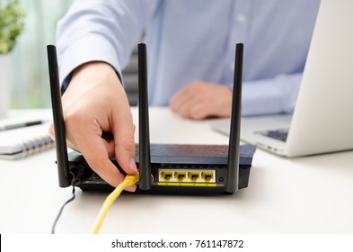 Man Plugs Ethernet Cable Into Router. Router Wireless Wire Broadband Home Office Cable Plug Concept