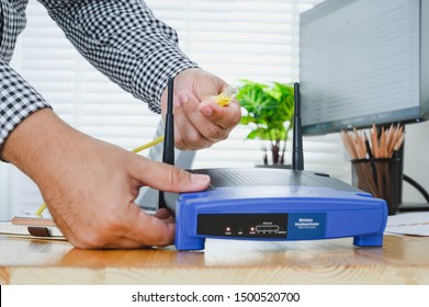 Man Plugs Internet Cable Into The Router. Router Wireless Wire Broadband Home Concept