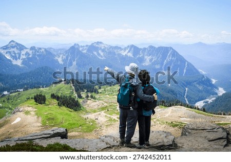 Man pointing to the distant view. Couple enjoying the view from Skyline Loop Trail. Mt Rainier National Park. Washington State. 