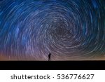 Man Pointing North in a spiral star trail